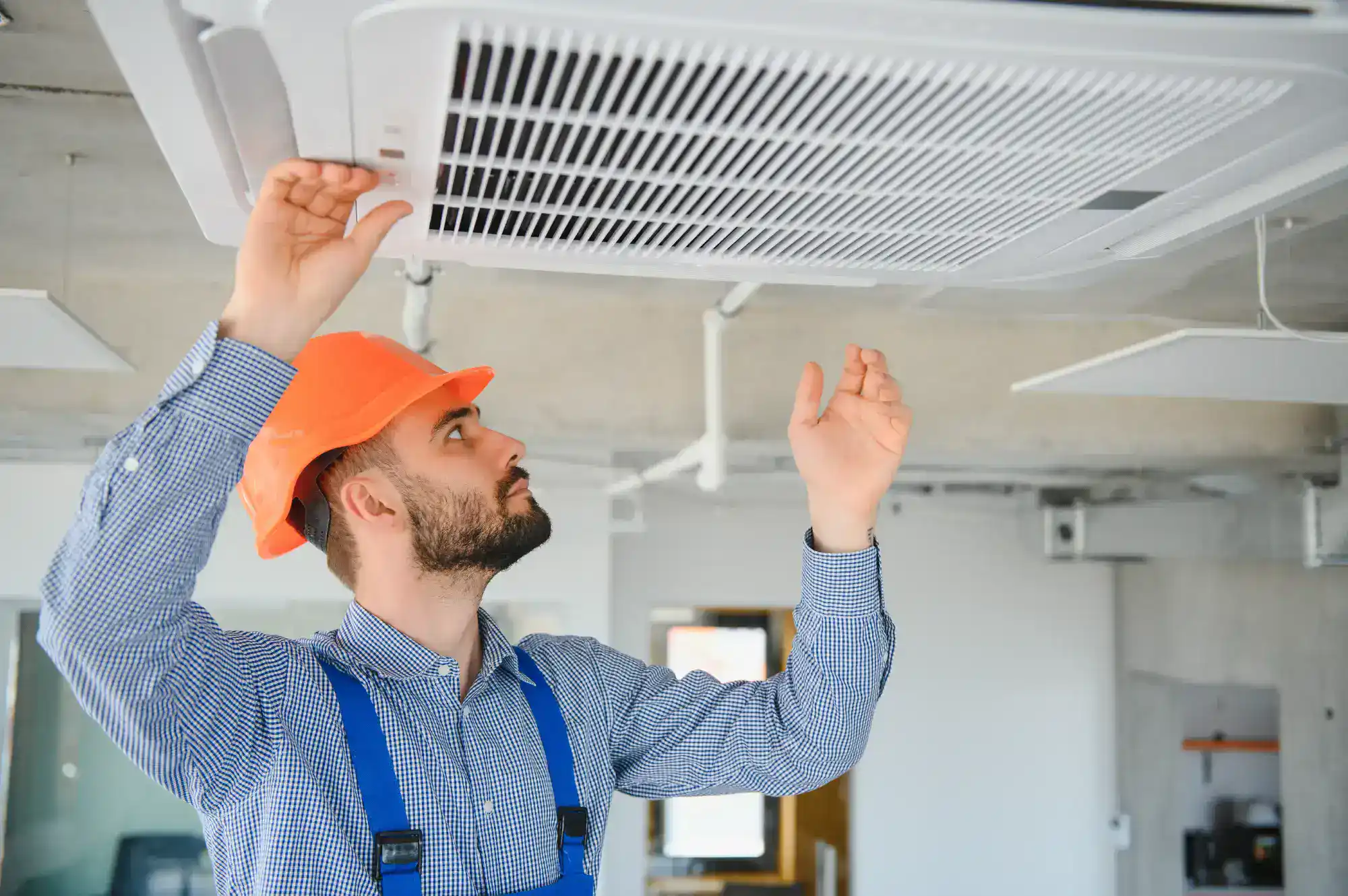 Technician inspecting air conditioner unit for repairs.