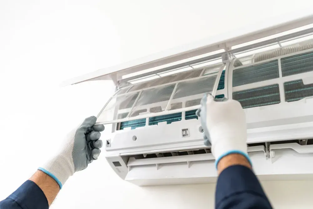 Technician repairing an air conditioner unit for optimal cooling.